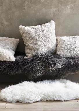 Sheepskin throws, rugs and cushions on bench